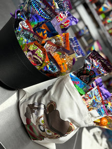 Halloween candy surprise buckets and totes filled with assorted spooky-themed candies, cotton candy, and mystery treats.