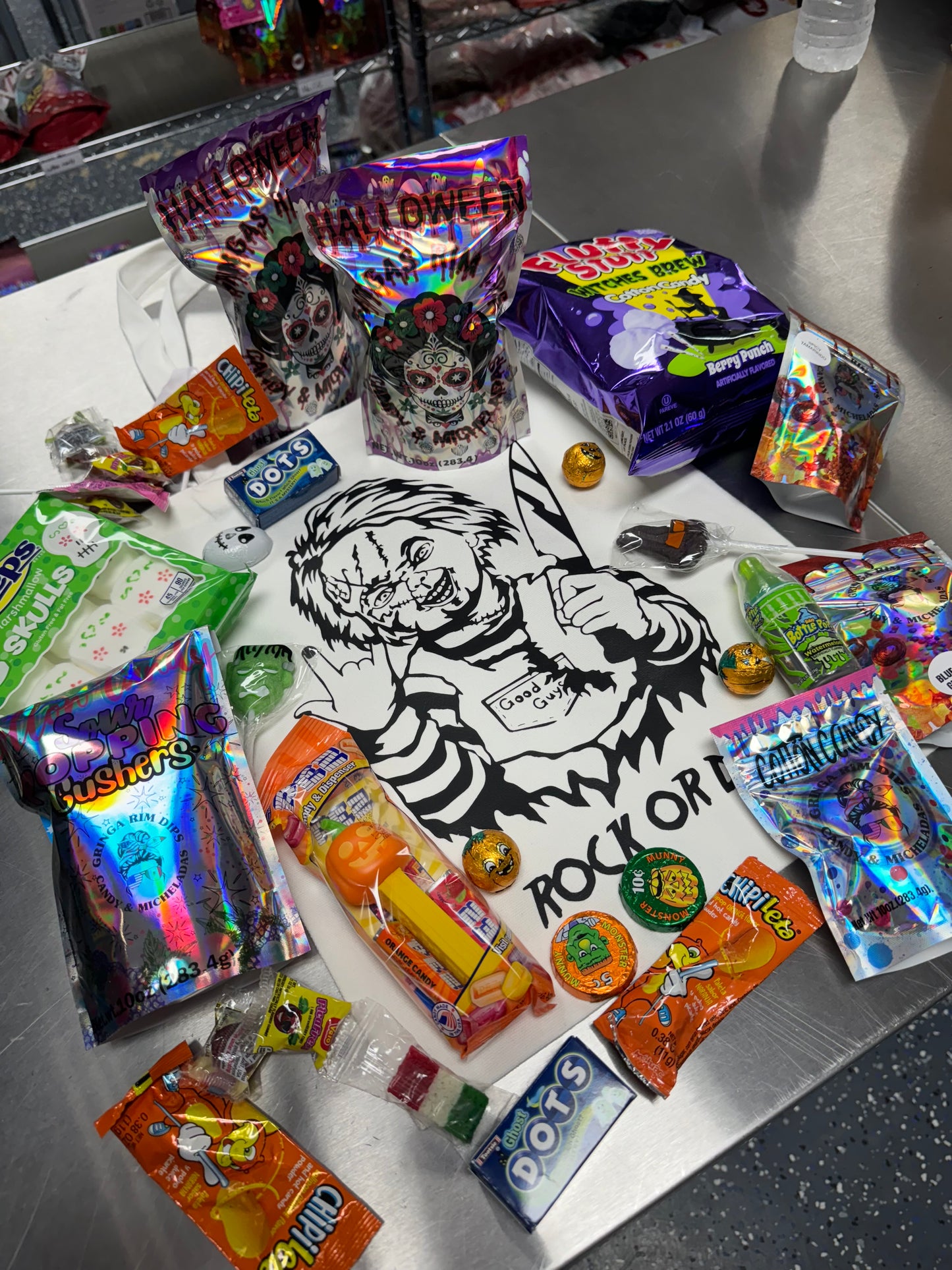 Halloween candy surprise buckets and totes filled with assorted spooky-themed candies, cotton candy, and mystery treats.