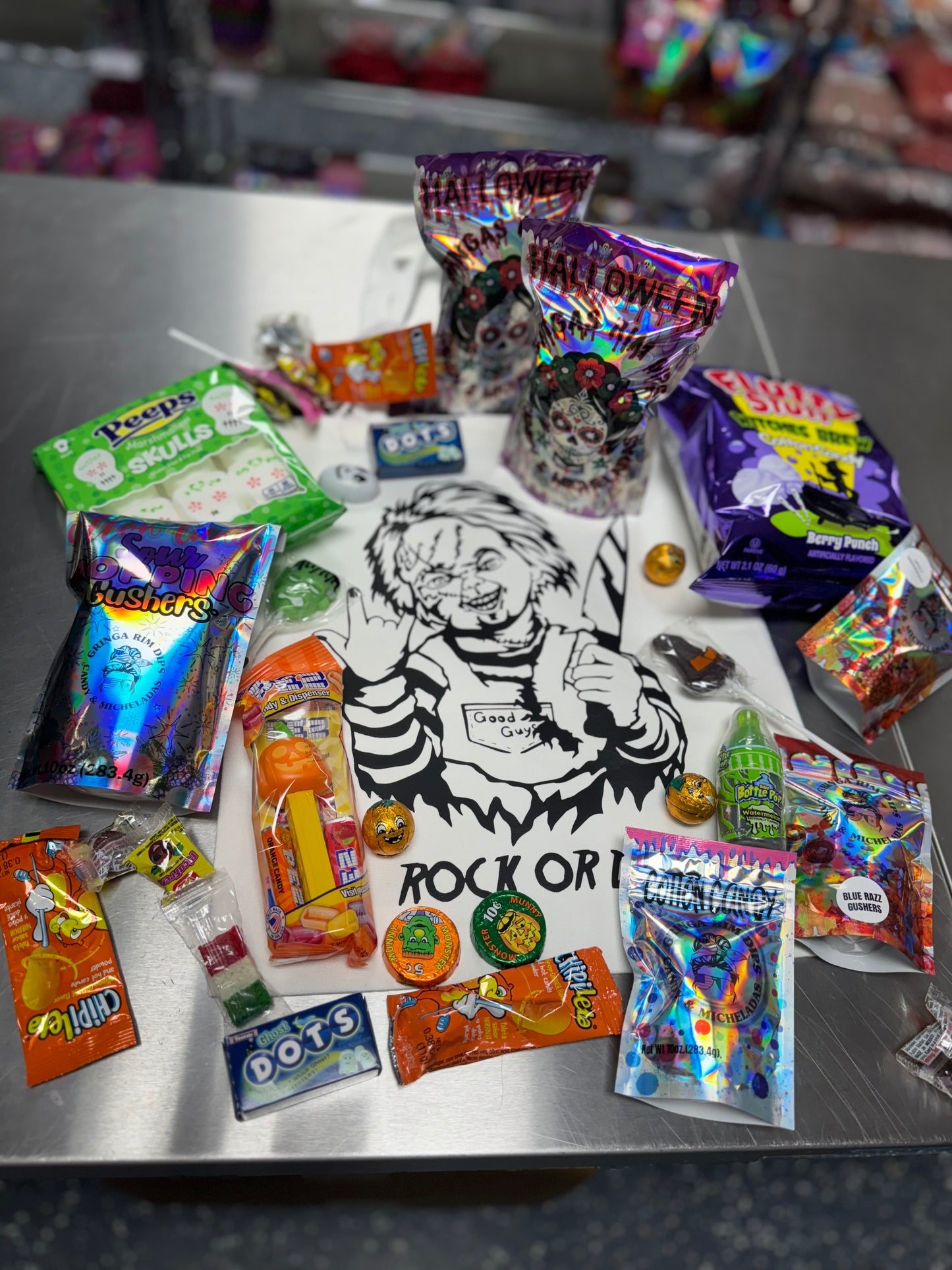 Halloween candy surprise buckets and totes filled with assorted spooky-themed candies, cotton candy, and mystery treats.